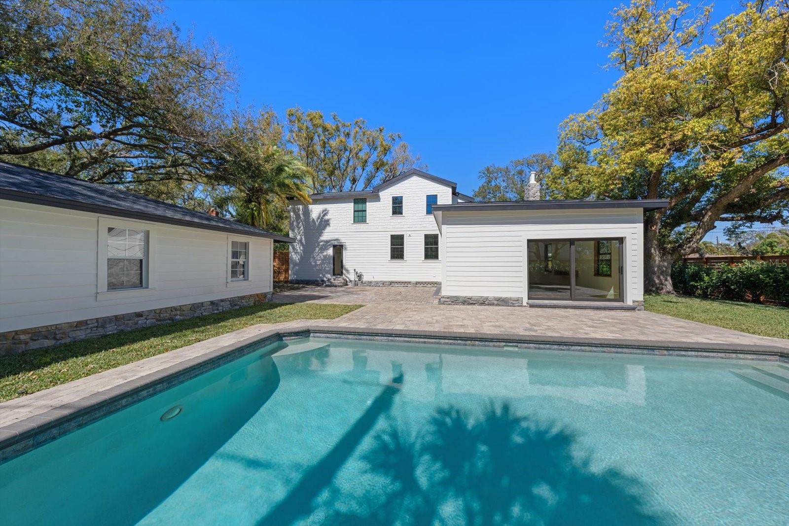 Expansive brick paver pool deck, surrounded by lush landscaping, lots of grass and beautiful 7' deep pool with sunshelf and lighting.  Oversized 2 car garage with alley access.
