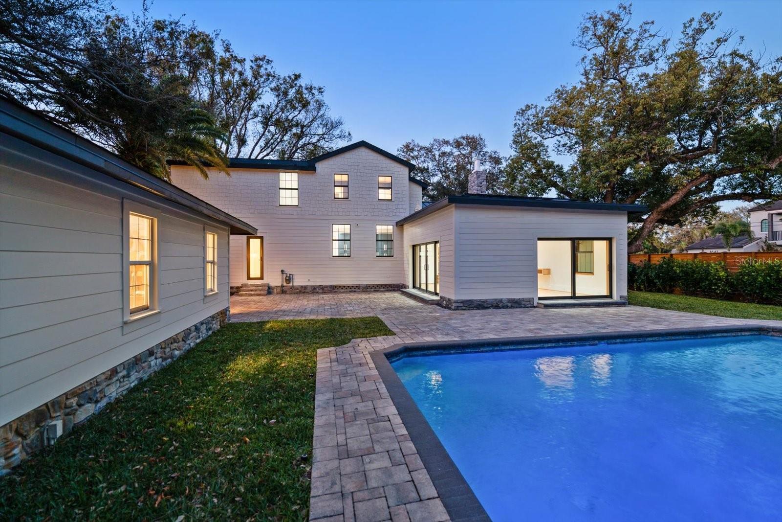 Expansive brick paver pool deck, surrounded by lush landscaping, lots of grass and beautiful 7' deep pool with sunshelf and lighting.  Oversized 2 car garage with alley access.