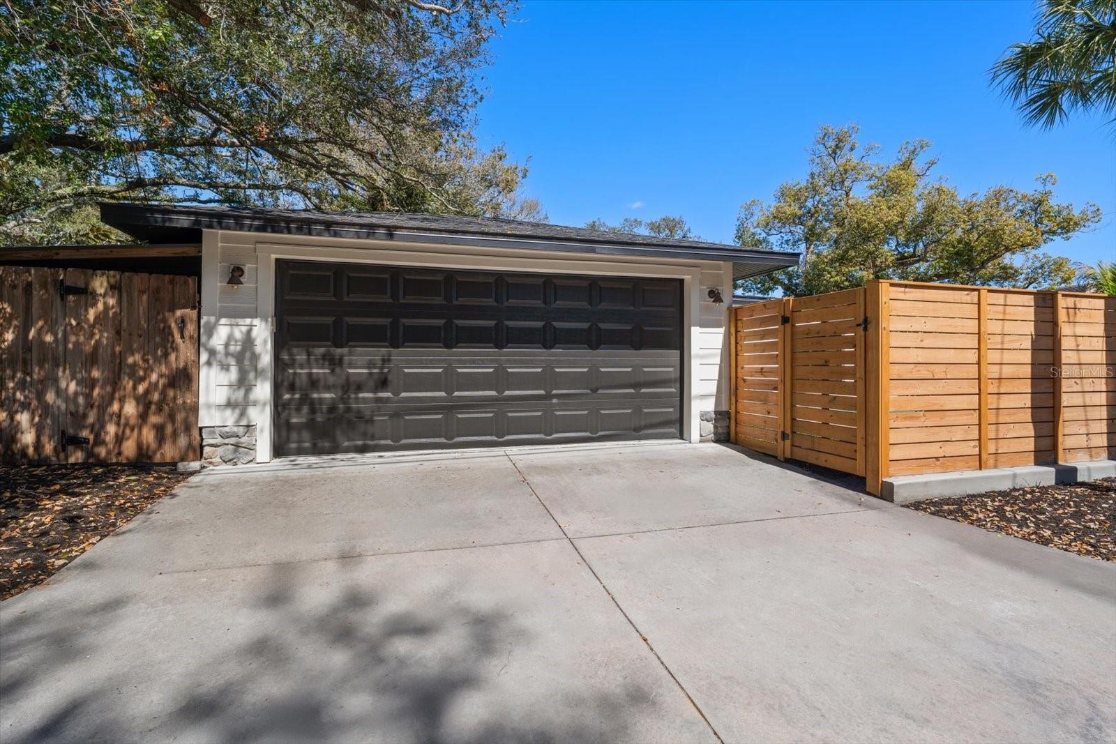 Alley access to oversized 2 car garage with hurricane rated garage door, garage door opener.  Extra parking space beside the fence in alley.  Storage shed for bikes and equipment.