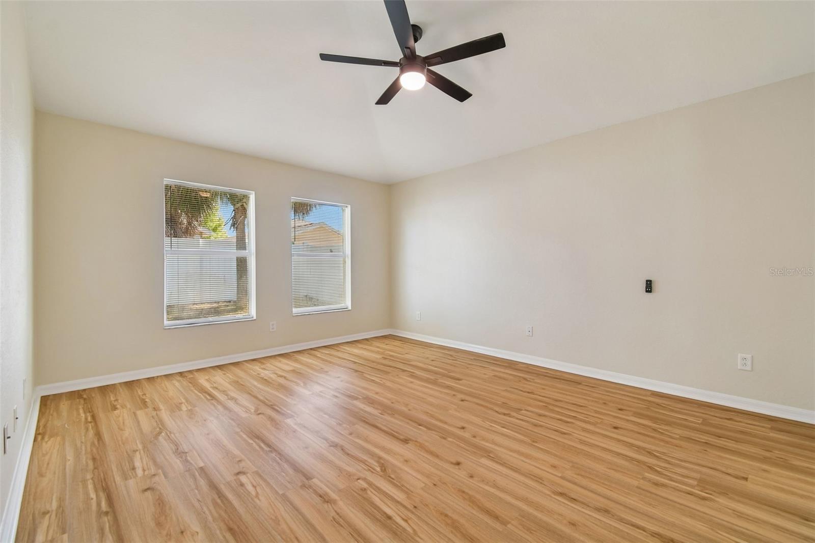 Warm wood look flooring and soft neutral tones create a calm, inviting atmosphere, while the oversized design easily accommodates larger furnishings with room to spare.