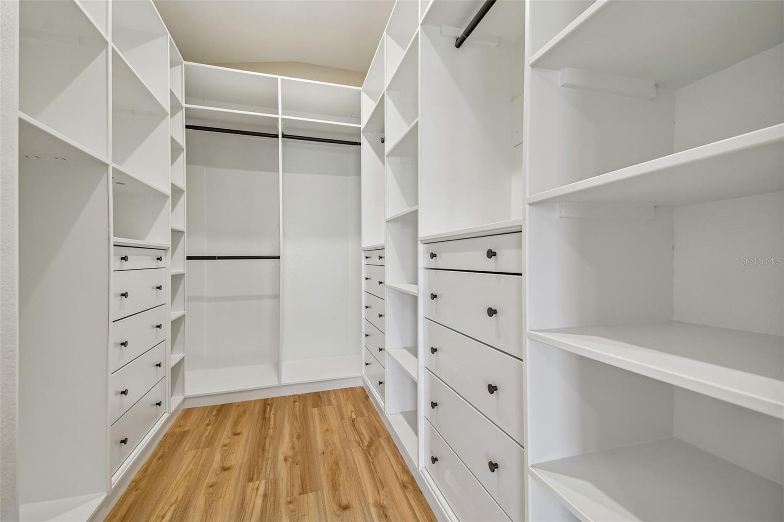 Dream walk in closet with custom built ins, abundant shelving, and drawer storage designed to keep everything beautifully organized.