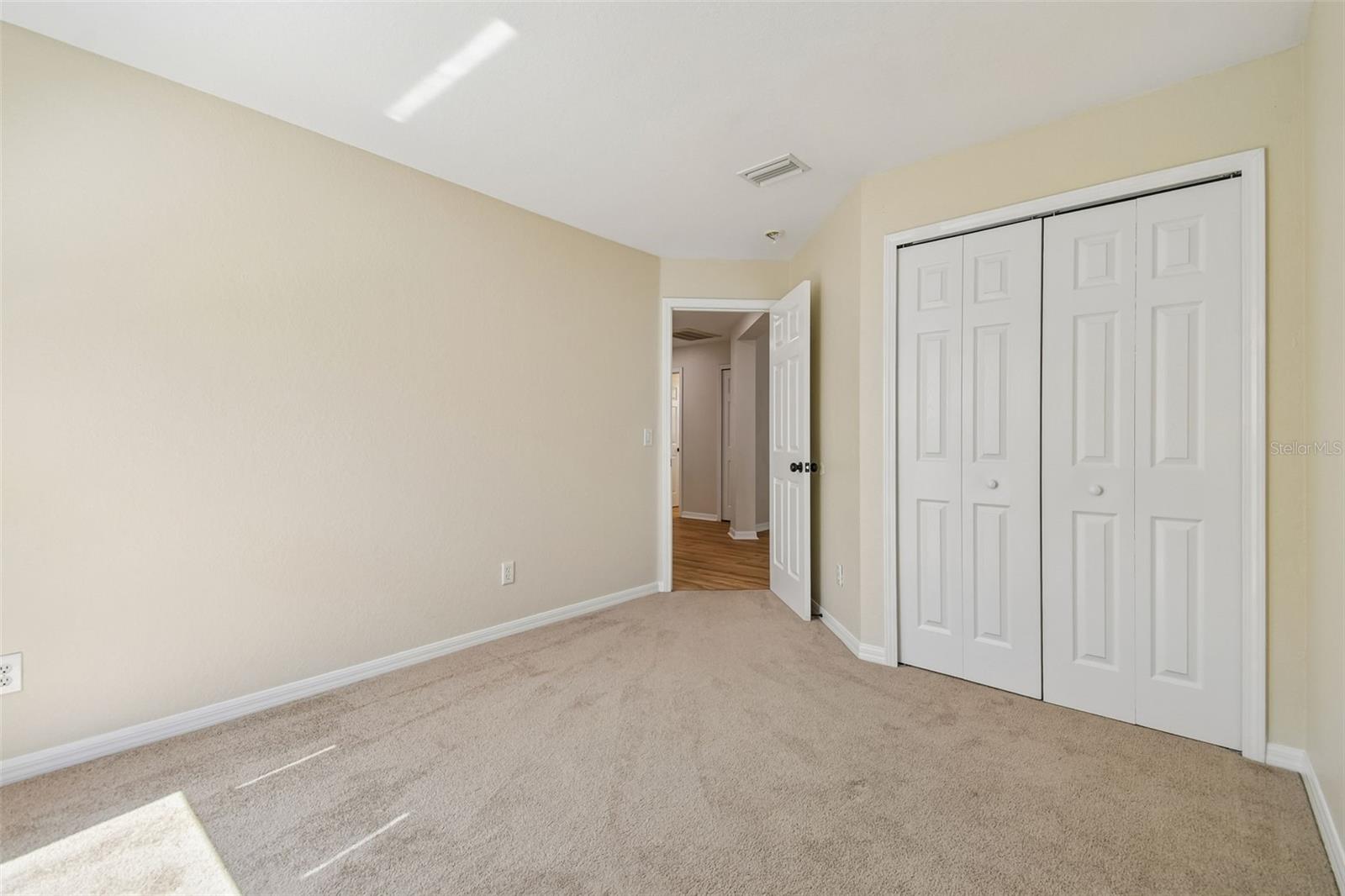 Secondary bedroom with a full size closet and flexible space for guests, work, or hobbies.