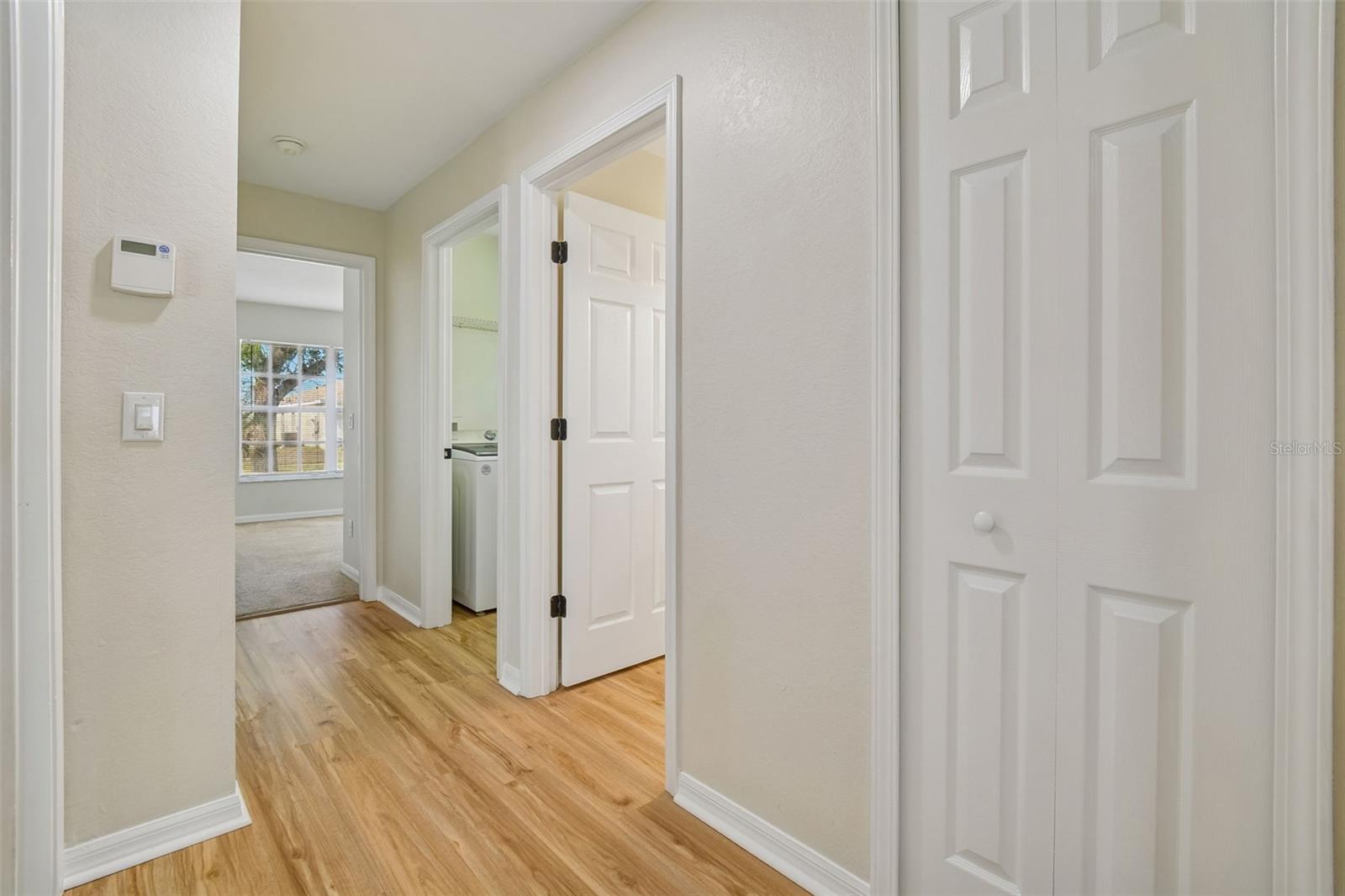 Hallway connecting the three secondary bedrooms and the guest bathroom for a functional and private split bedroom layout.