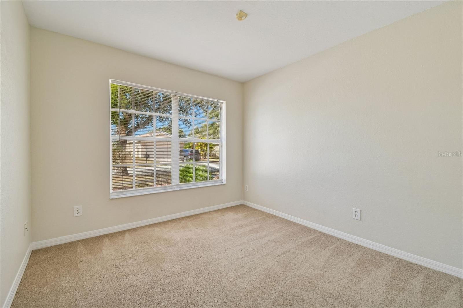 Versatile fourth bedroom bathed in natural light, easily adaptable as a home office, playroom, or additional guest suite.