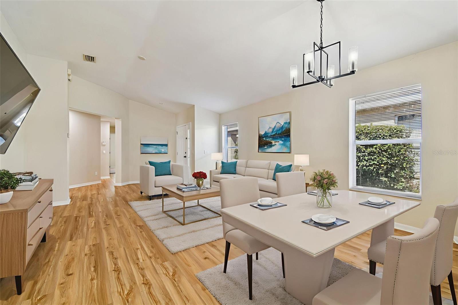 As you step inside, you’re greeted by a bright and airy open living and dining space filled with natural light, warm wood-look flooring, and clean, modern finishes.