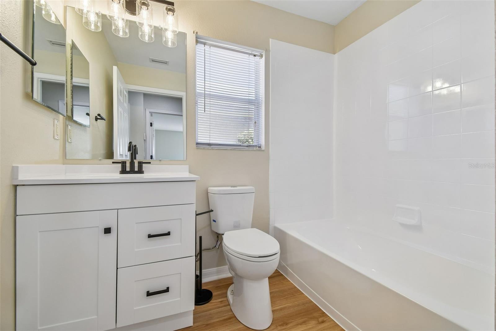 Updated guest bathroom featuring a modern vanity, sleek fixtures, and a clean tub and shower combination.