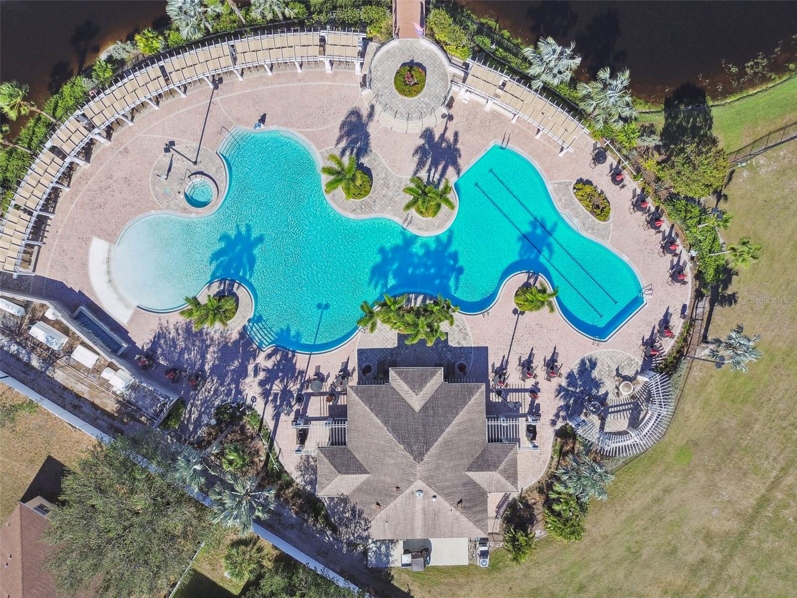 Sparkling main pool with zero entry area and spa surrounded by pavered lounging space ideal for soaking up the Florida sunshine.