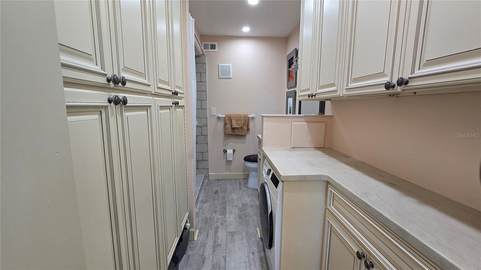 Primary Bathroom with loads of cabinets as well as washer hookup.