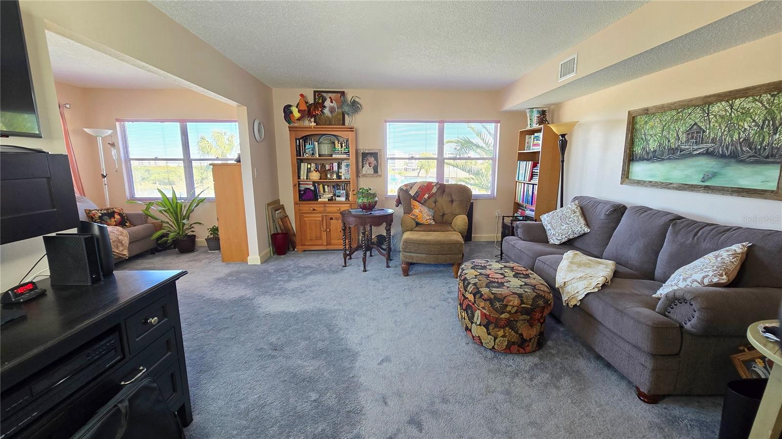 View from the dining room to the Living Room and Den/Family Room with natural lighting.