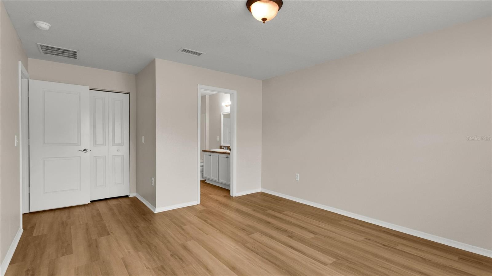 Reverse view of primary bedroom showing ensuite.  Closed door is the walk-in closet.