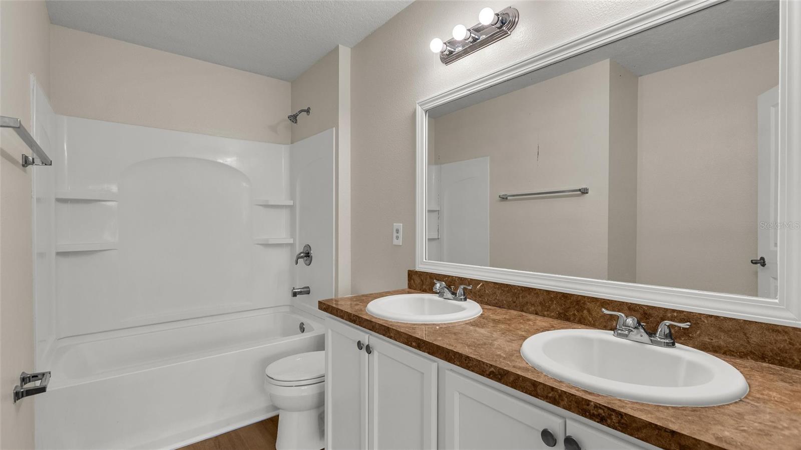 Primary ensuite has double sink vanity and tub with shower.