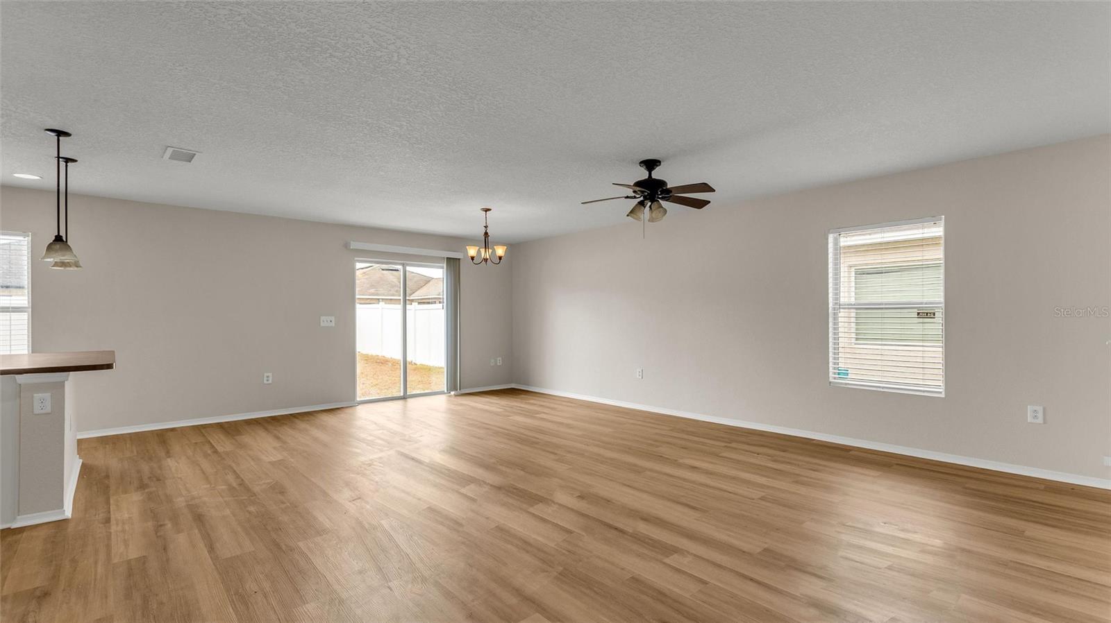 Great room that is open to the kitchen with lots of natural light!  Look at the beautiful new luxury plank vinyl flooring!