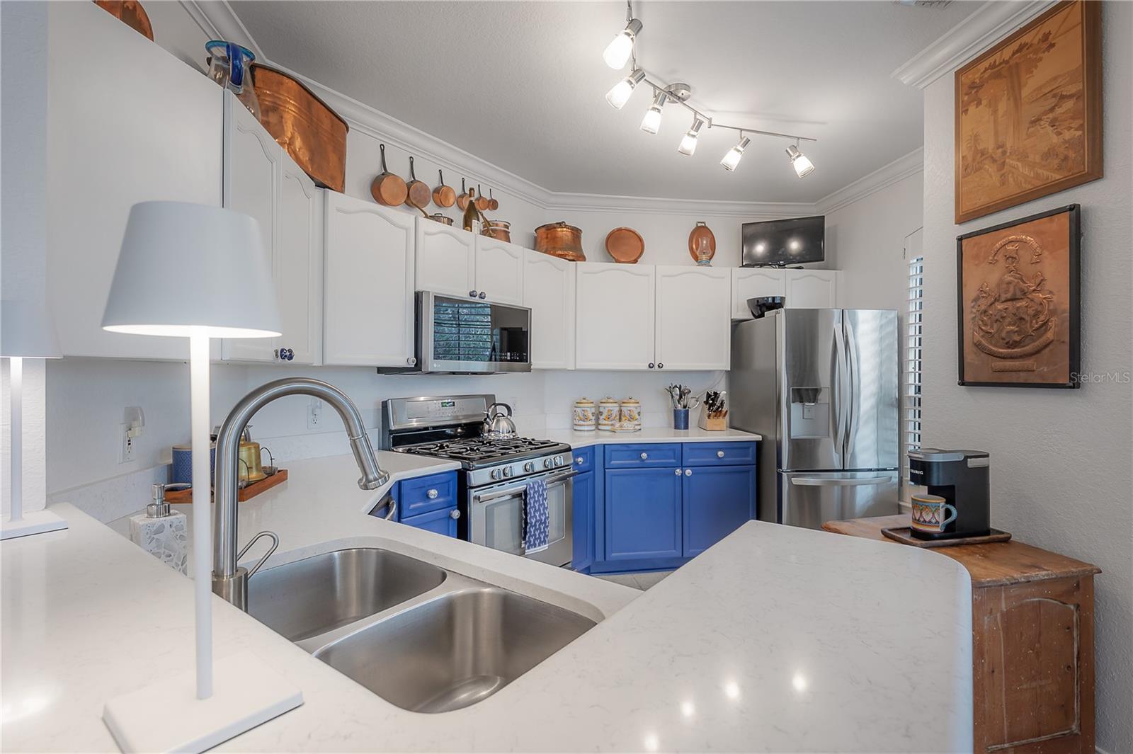 Kitchen with quartz countertops, stainless steel appliances, and pantry closet