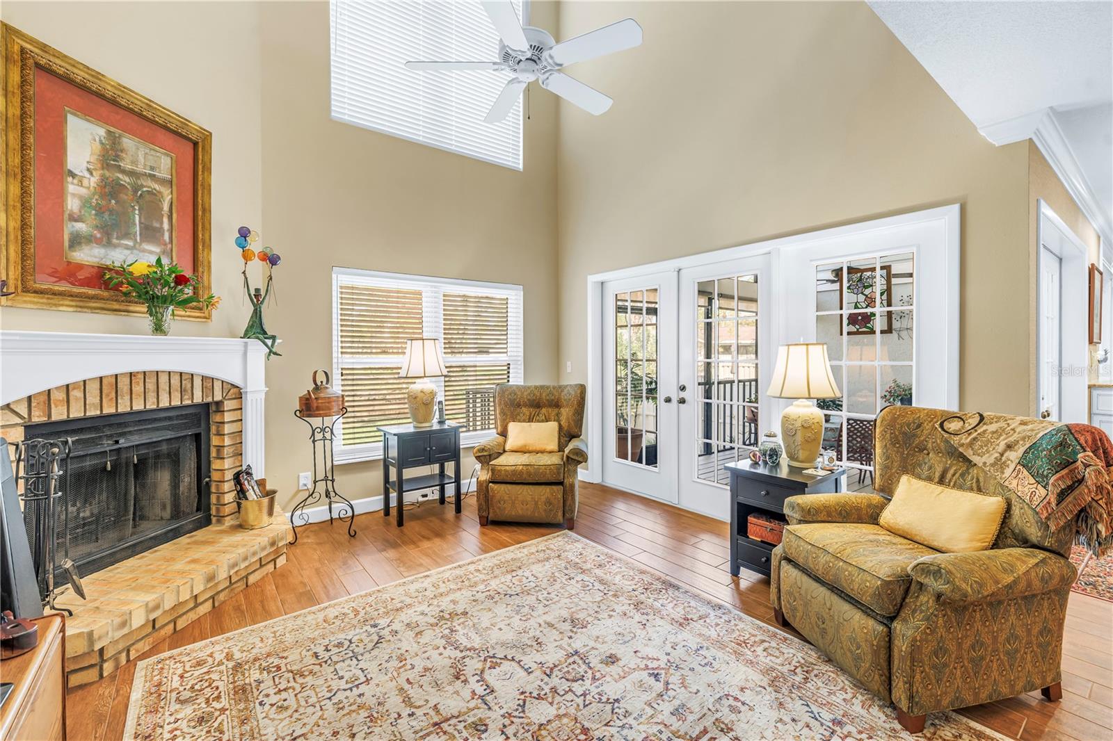 Spacious Living room with Abundant Natural Light, French Doors to Screened Porch and wood burning fireplace