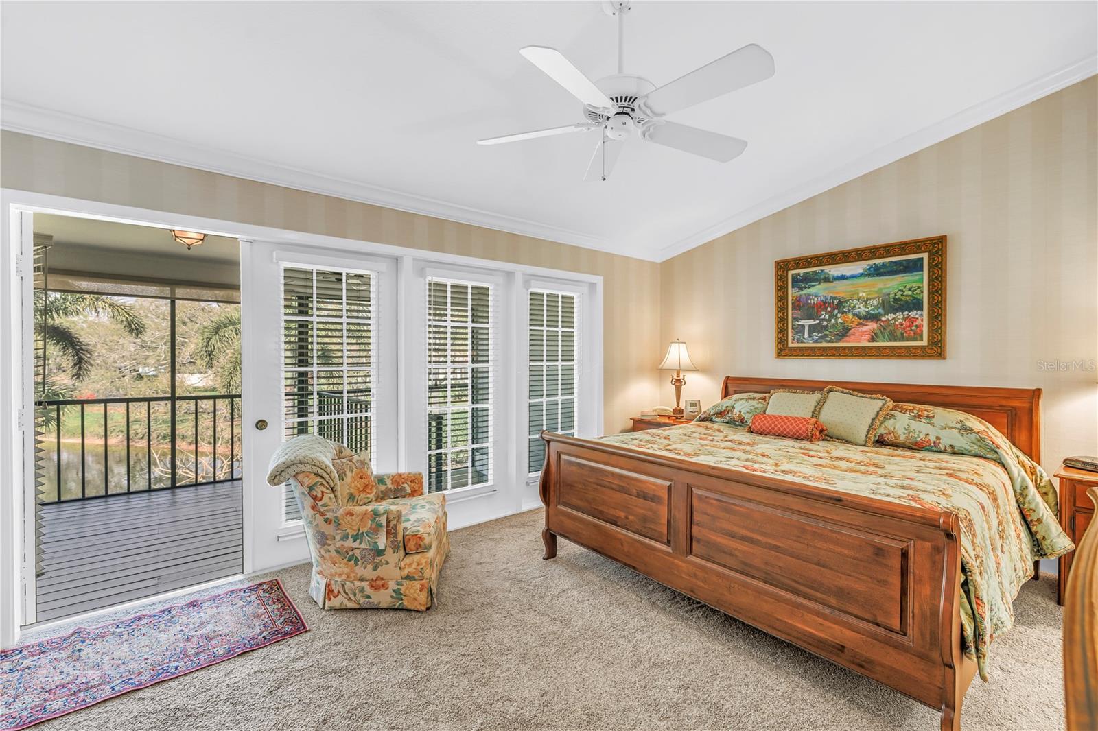 Primary Bedroom with Soaring Vaulted Ceiling, Crown Molding, Custom Wall Covering, and Screened Porch