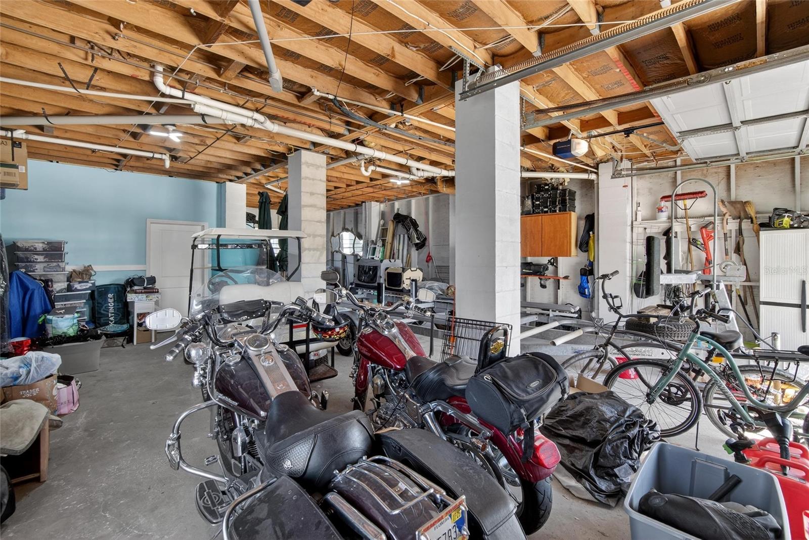 They are moving!  This is the large storage area enclosed under the home.  Behind the blue wall is an office.  This space would easily hold three cars.  Right now it has a boat trailer stored in it and the golf cart.