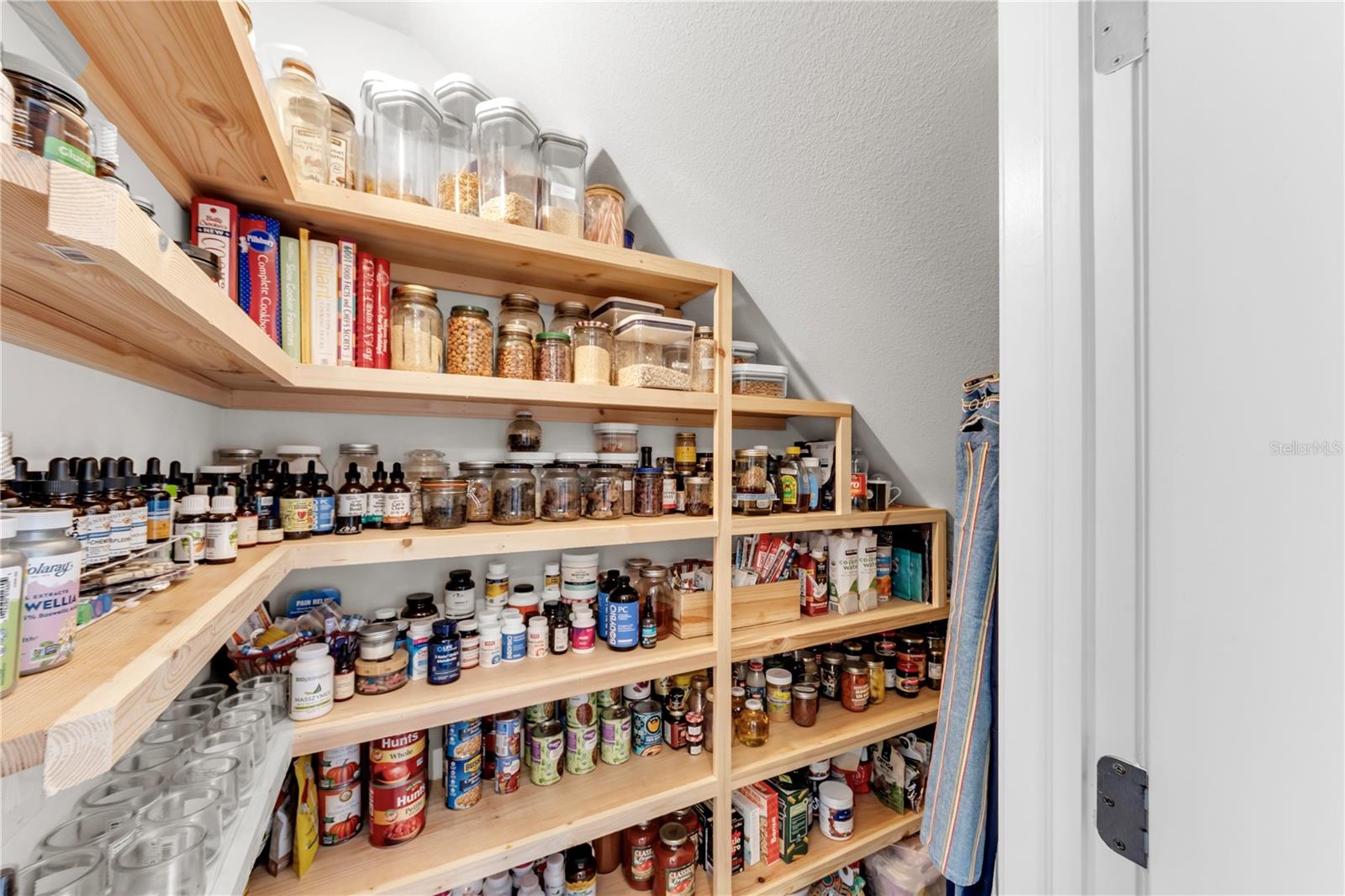 The owners have even installed full walk in SPICE cabinet and storage shelving system under the stairs next to the kitchen.