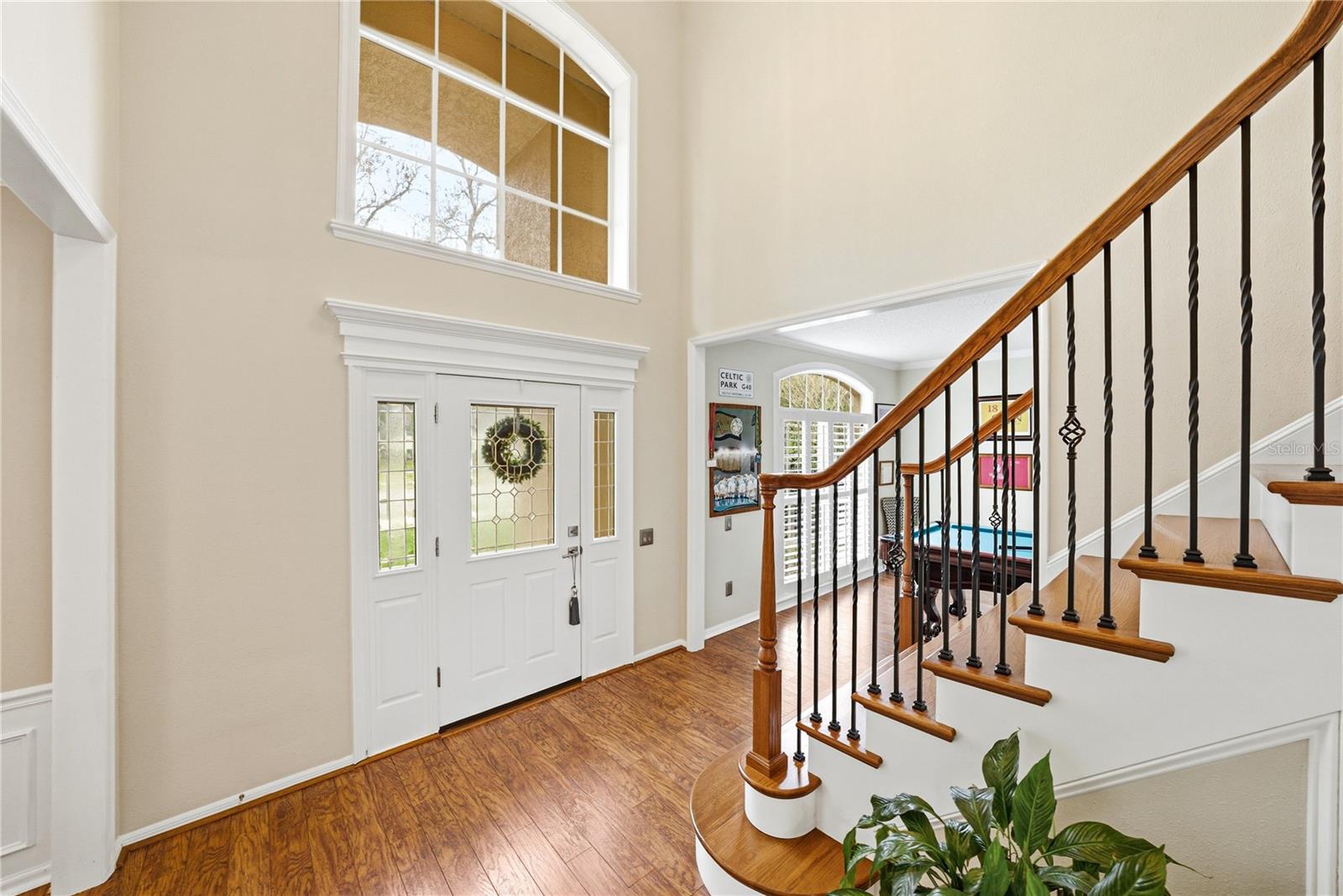 Open Two Story Foyer with Wood Staircase and Laminate Floors