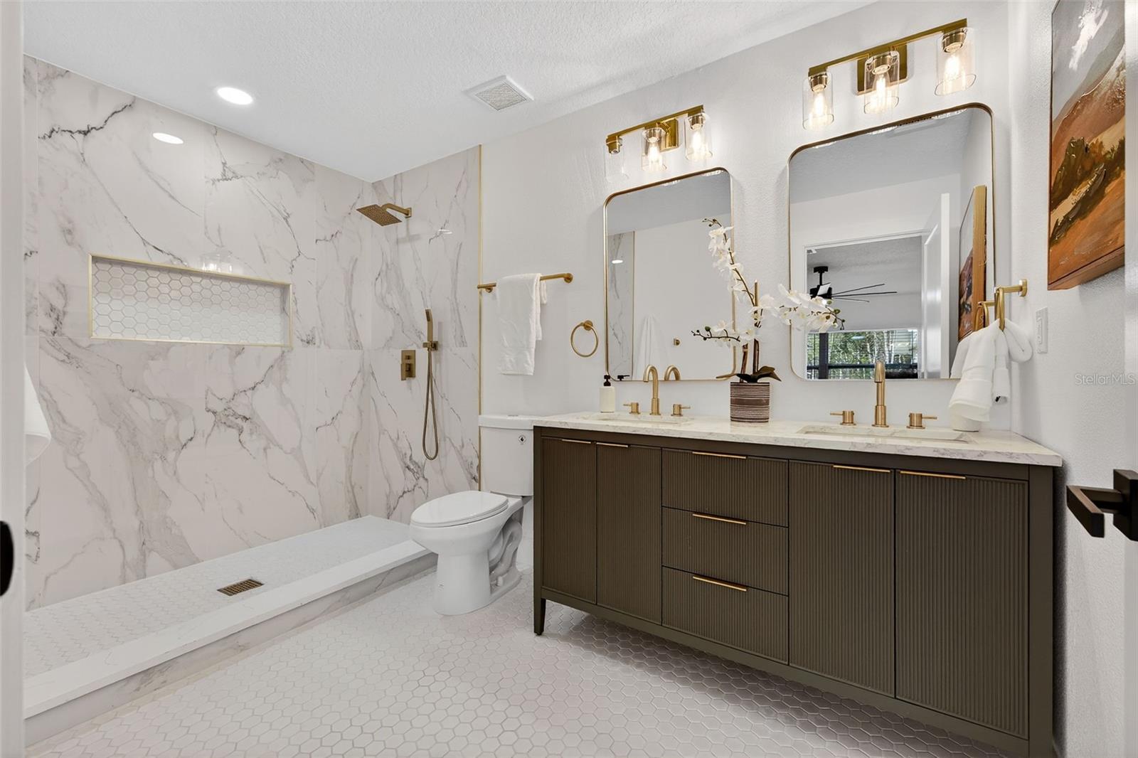 Dual vanities with gold fixtures and designer finishes