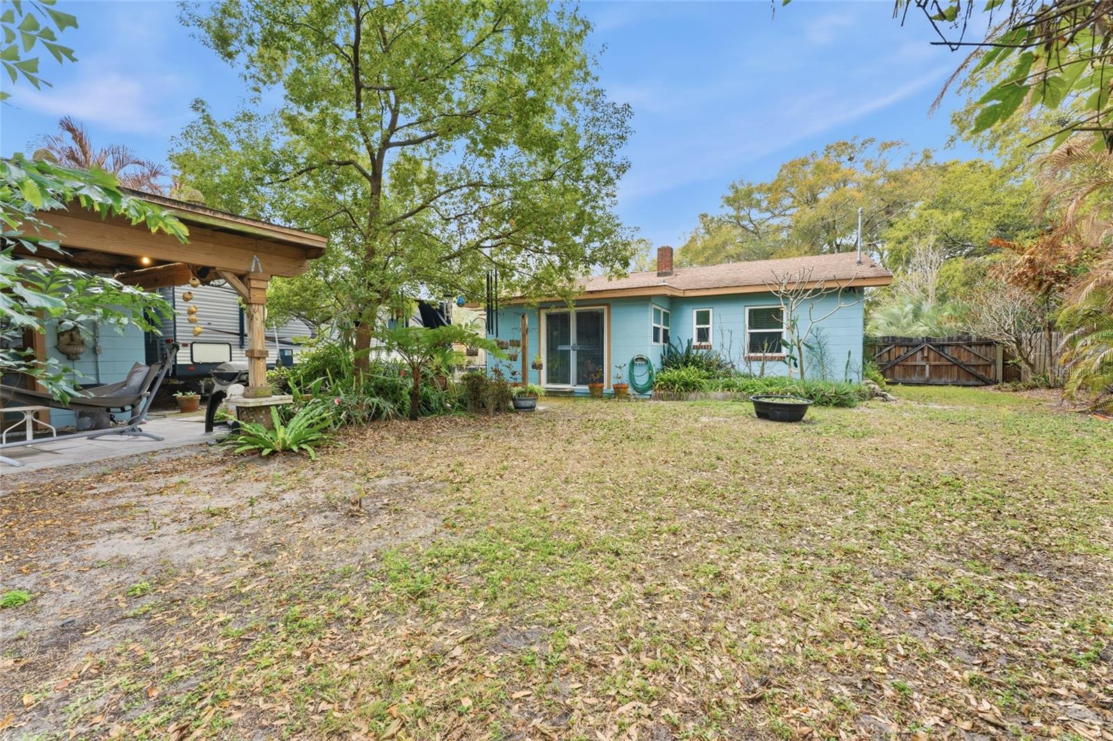 large backyard looking towards studio on left and house on right