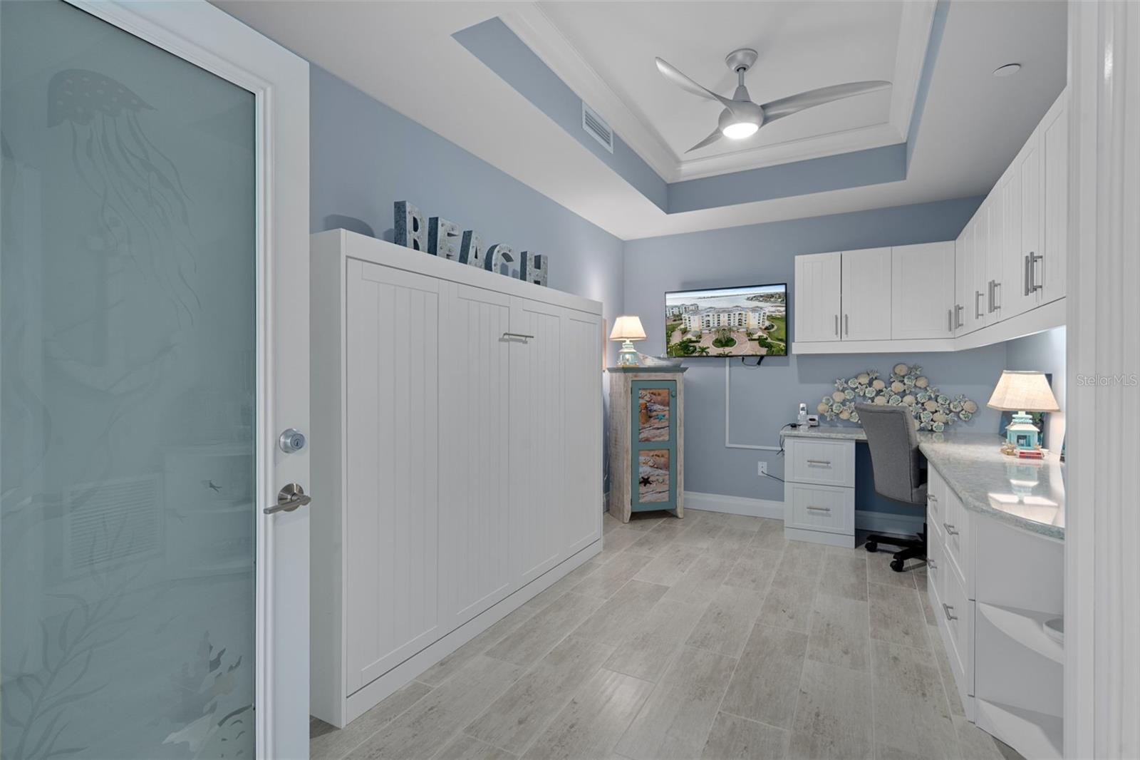 The large office/den features custom wood cabinetry.