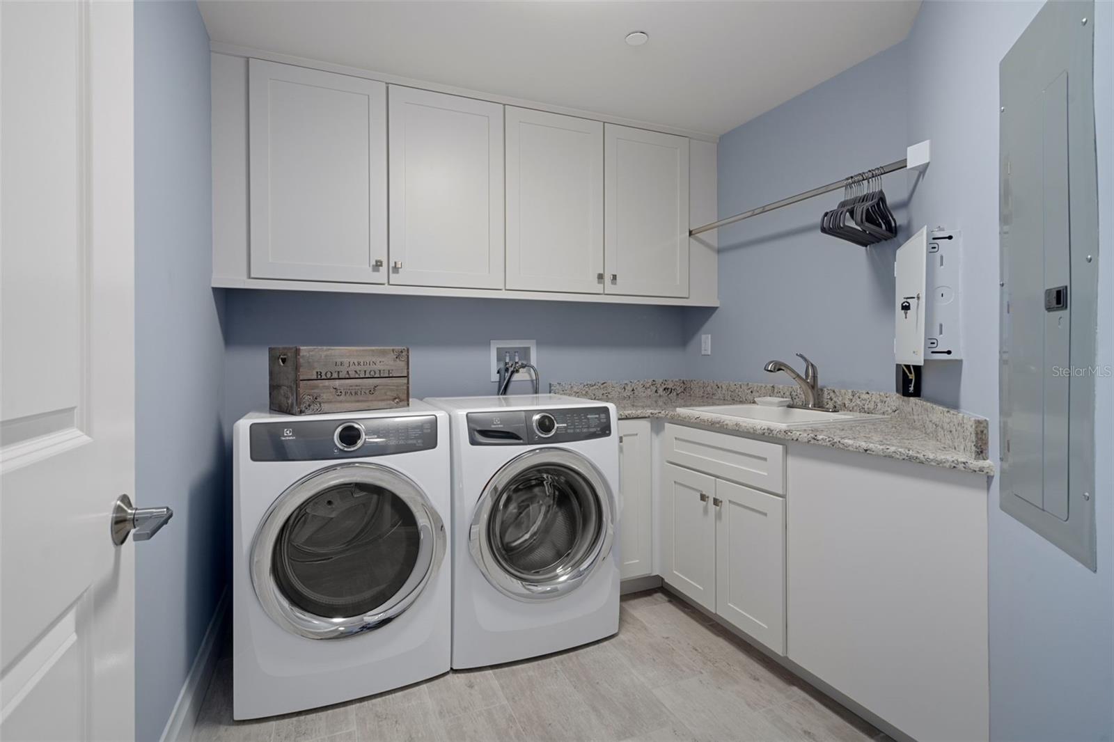 Dedicated laundry with plenty of cabinetry and a utility sink.
