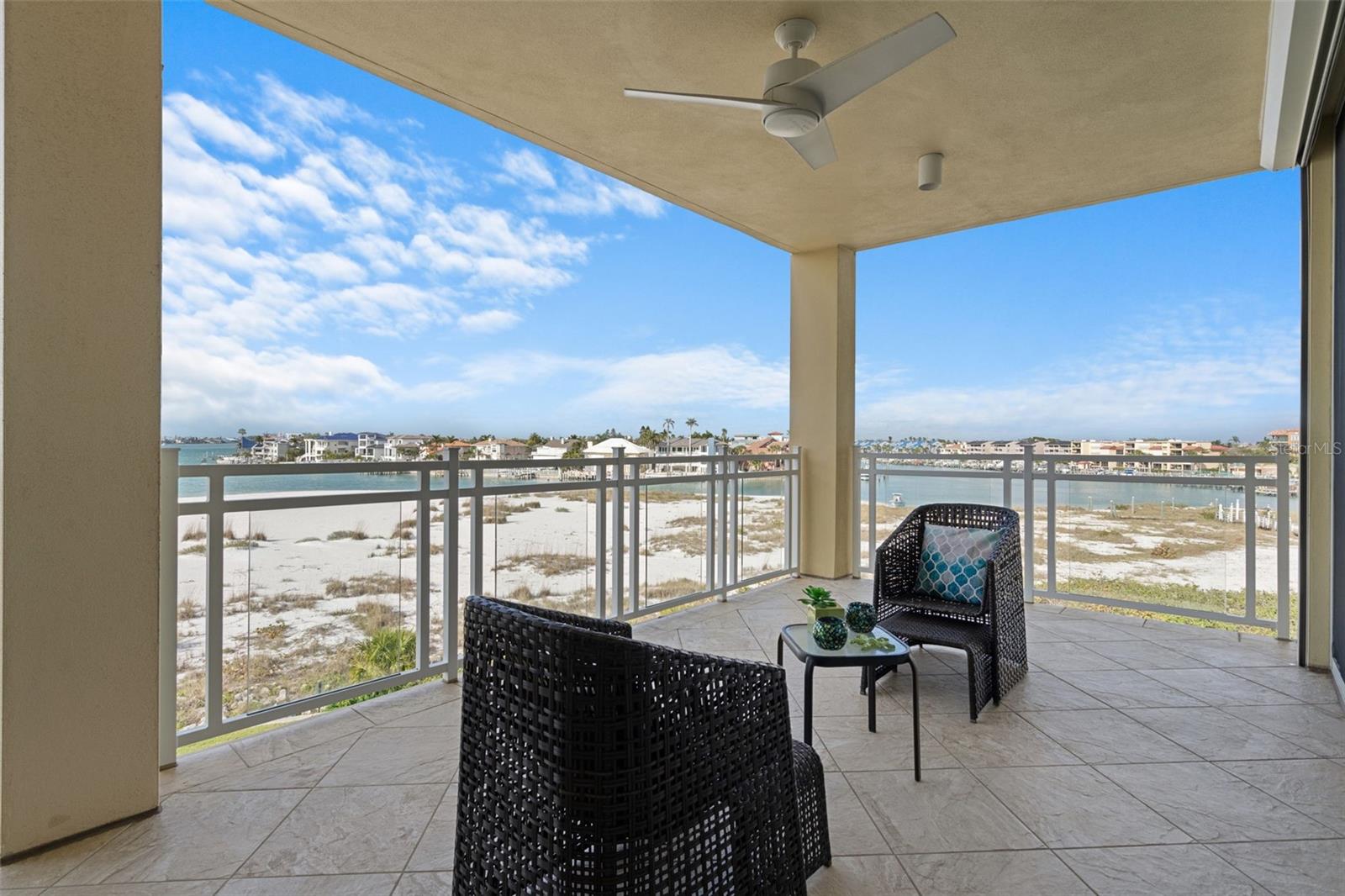 The large covered balcony with ceiling fan has plenty of space for an outdoor dining table + couch  arrangement