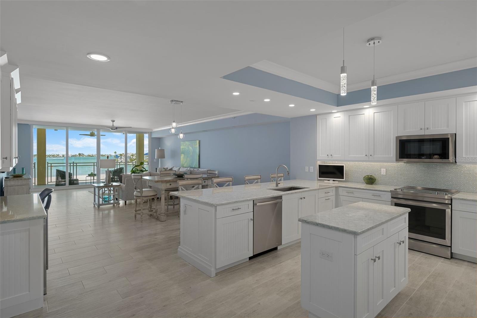 The light, bright kitchen features custom wood cabinetry, stainless appliances and quartz counters.