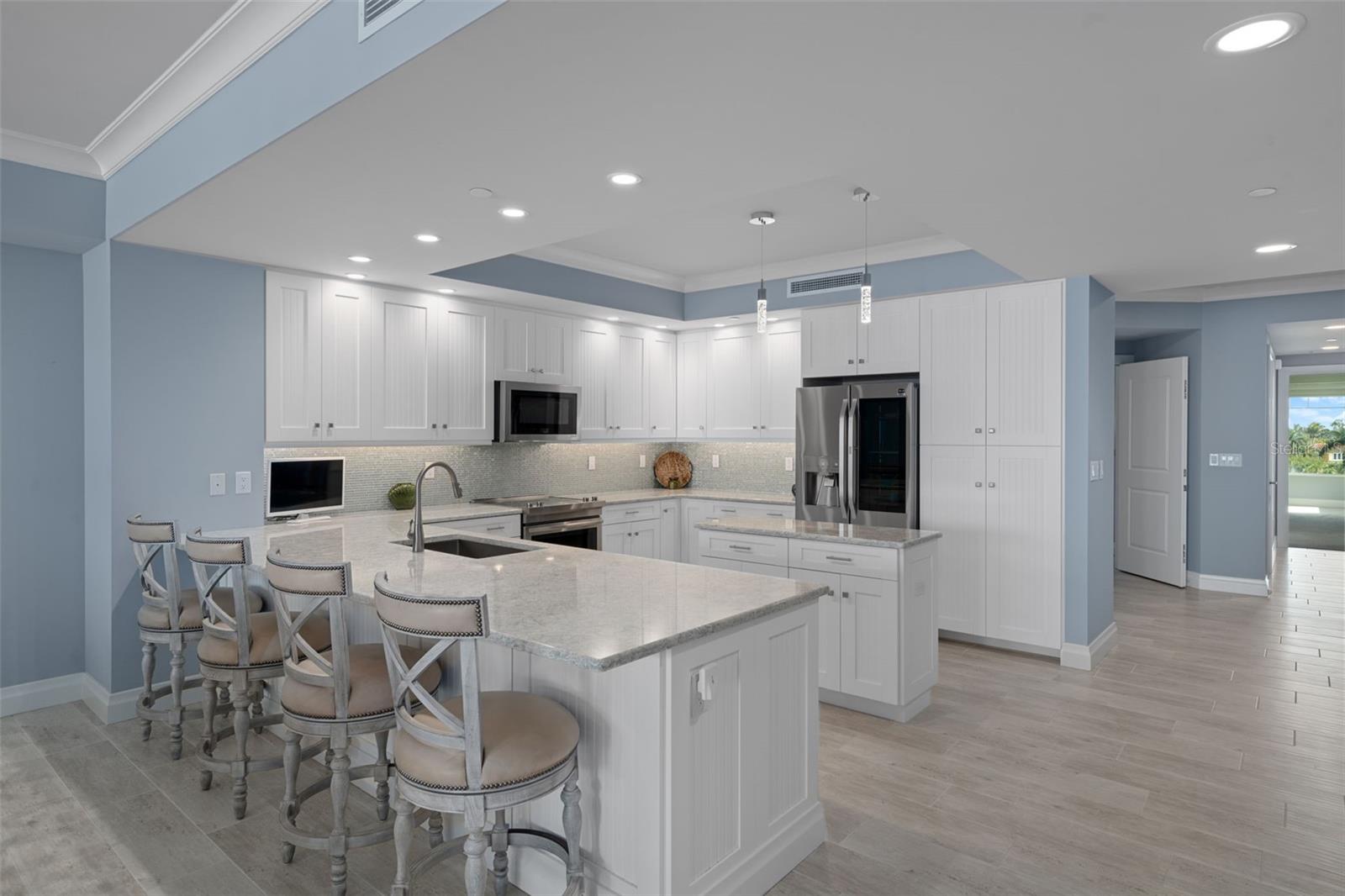 The large kitchen with expansive bar provides seating for 4.