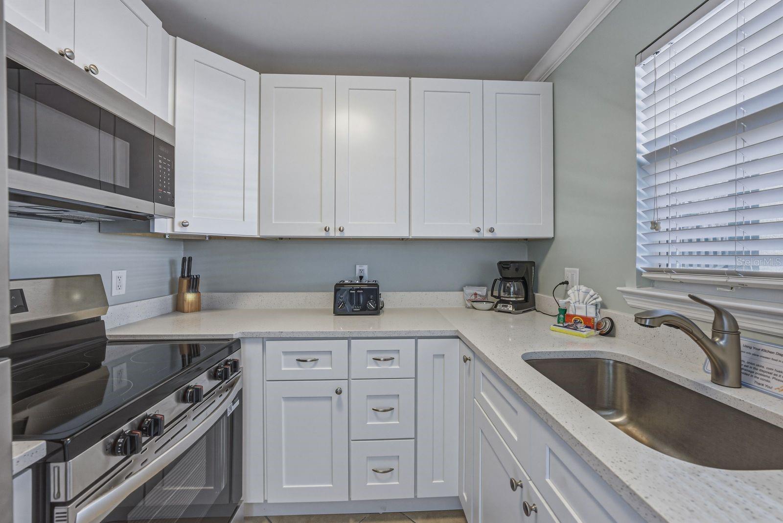 Full sized new stainless appliances in new kitchen with quartz countertops