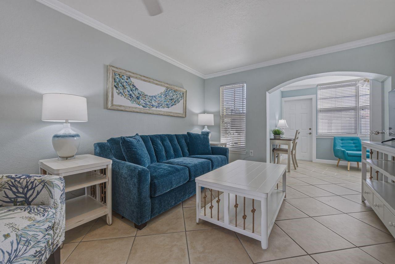 Living room with sun room in distance. Furnished as seen