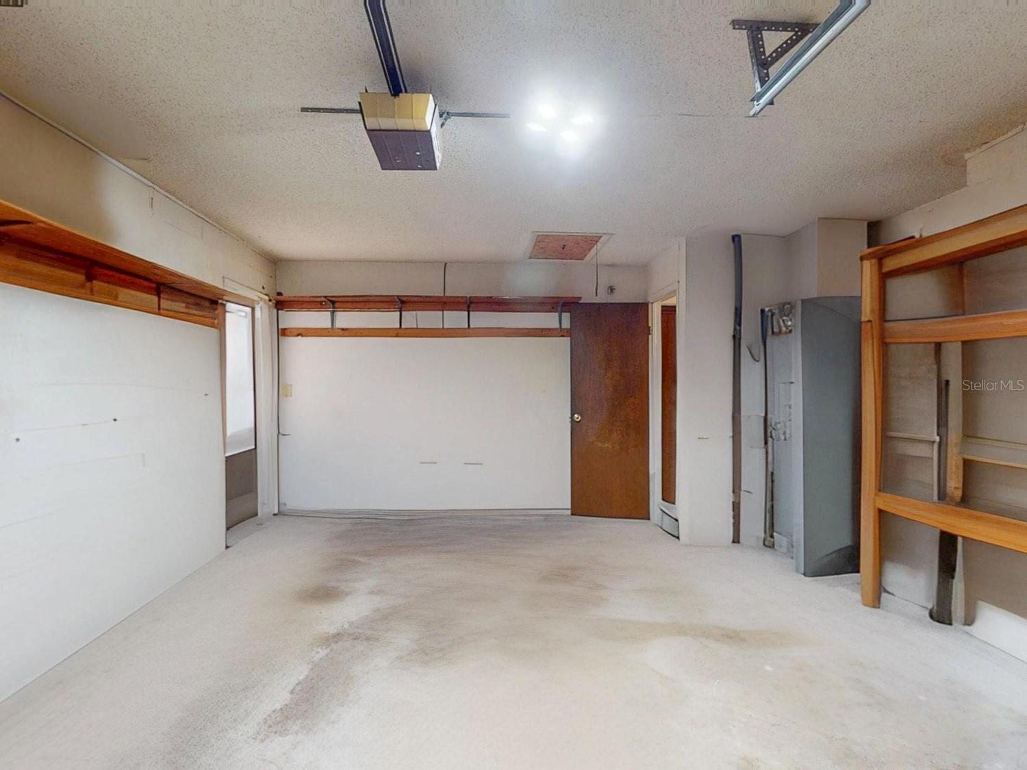 Generous garage space with built-in shelving- perfect for storage, hobbies, or a small workshop.