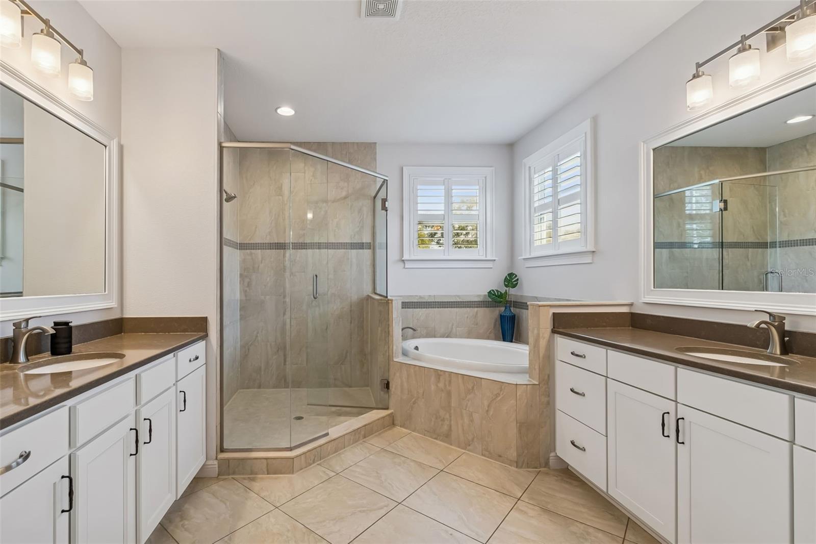Spa-like primary bathroom with soaking tub and glass shower.