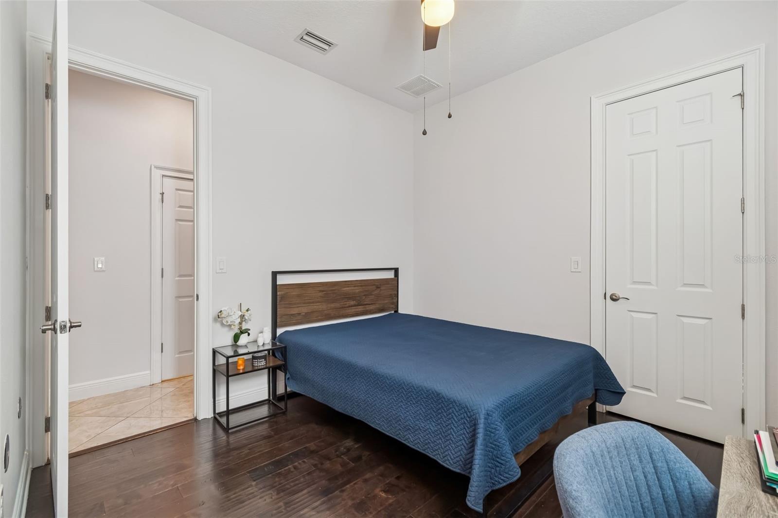 Bright guest bedroom with twin beds and plantation shutters.