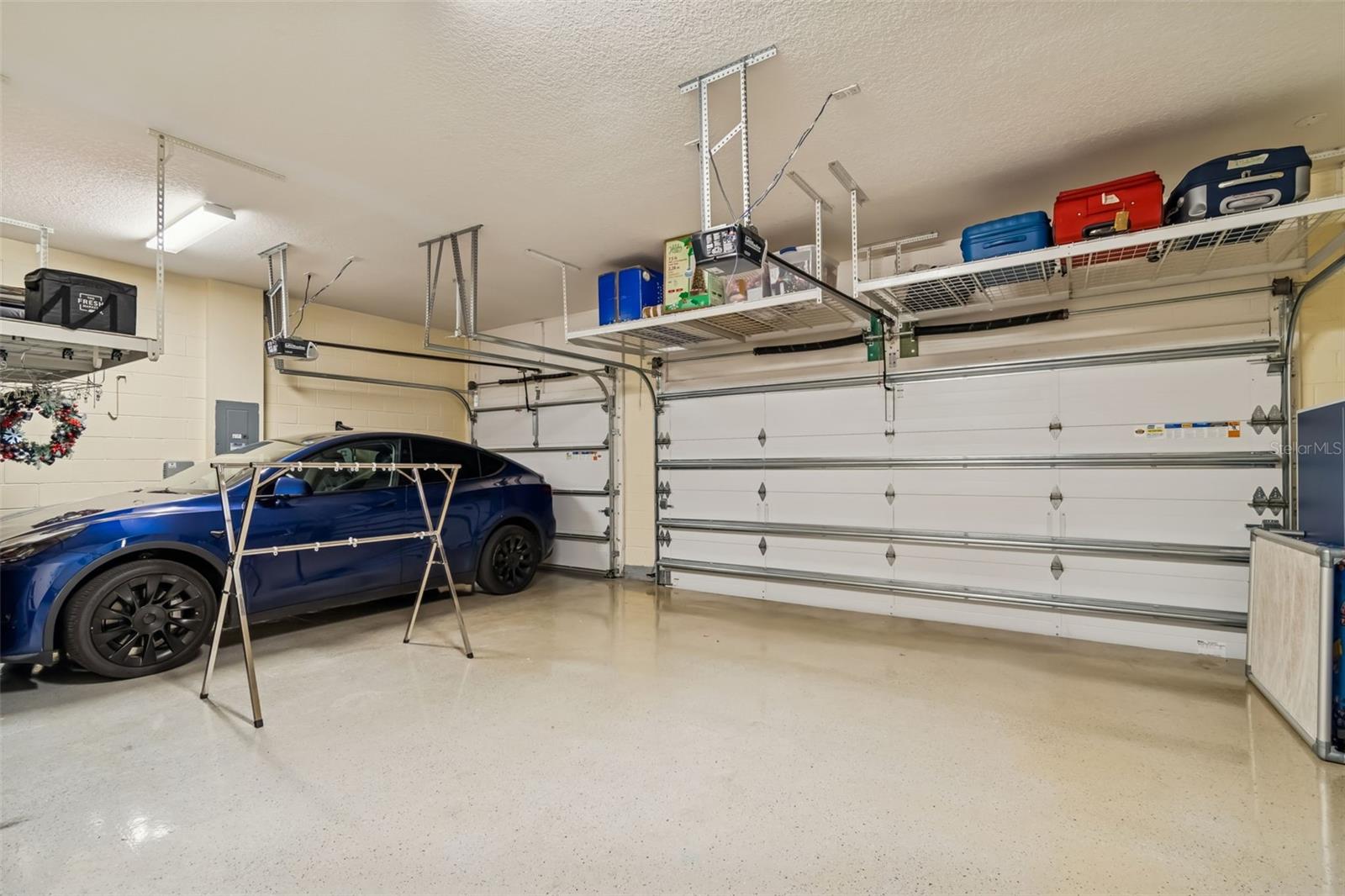 Oversized three-car garage with ceiling storage and epoxy floors.