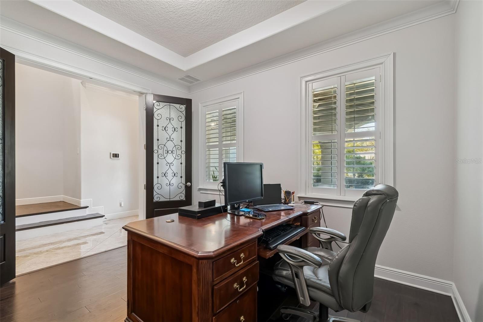 Den / Welcoming foyer with decorative glass door and private office.