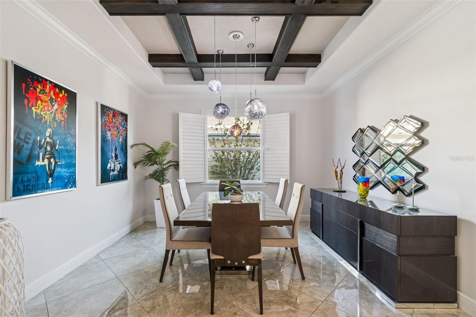 Stylish dining room with coffered ceiling and modern lighting.