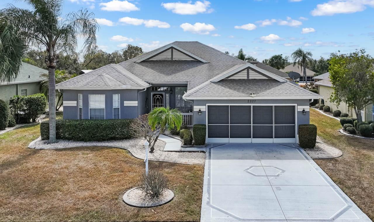 Beautifully maintained Pompano model featuring a decorative concrete driveway, sleek modern exterior paint, and professional xeriscape landscaping. The covered front entry and gated courtyard provide a private and welcoming first impression.