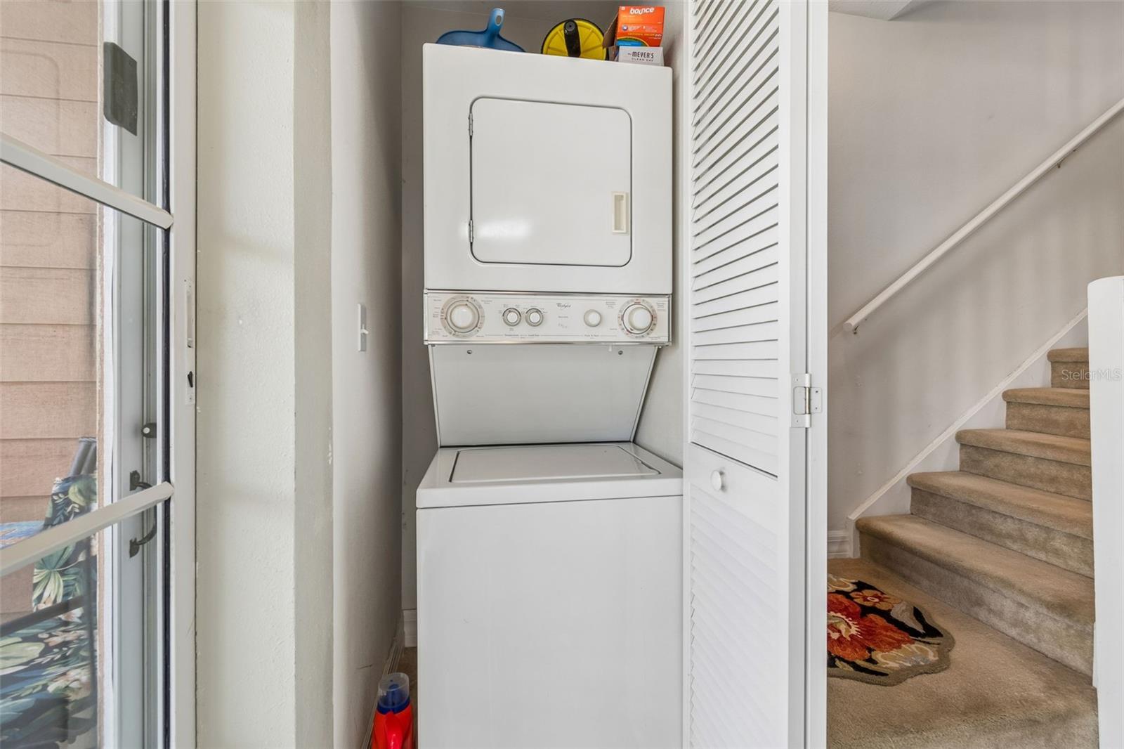 Stackable washer and dryer stay located off the back of the kitchen