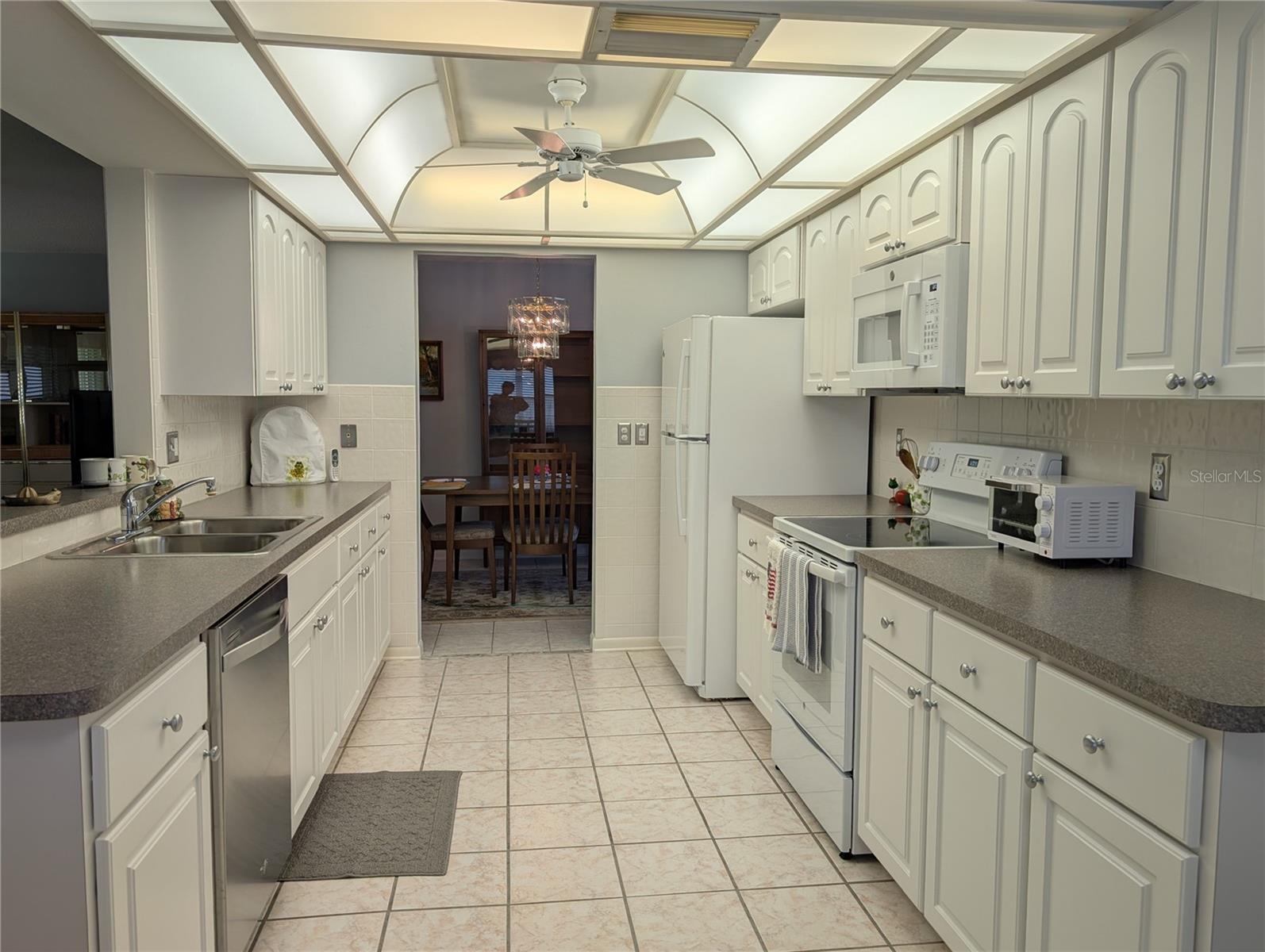 View thru kitchen to dining room. Pass thru window into Florida room on left. (Dishwasher was replaced with white Whirlpool dishwasher).