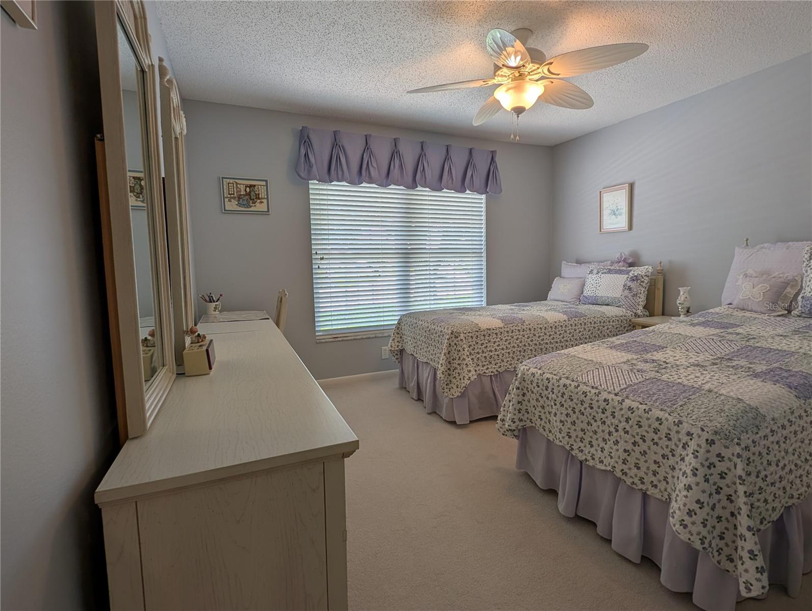 Bright, relaxing guest bedroom can easily accommodate a king bed.  Additional features include neutral carpeting, soothing decor, updated ceiling fan, Venetian blinds w/valance, large window and spacious closet.