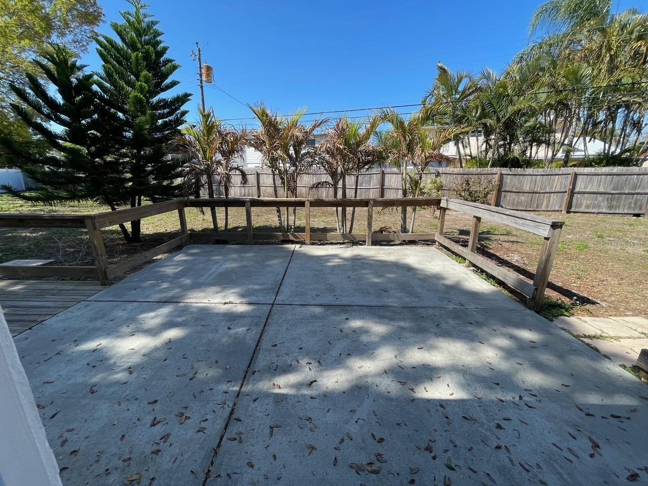 Backyard concrete patio & porch area side view