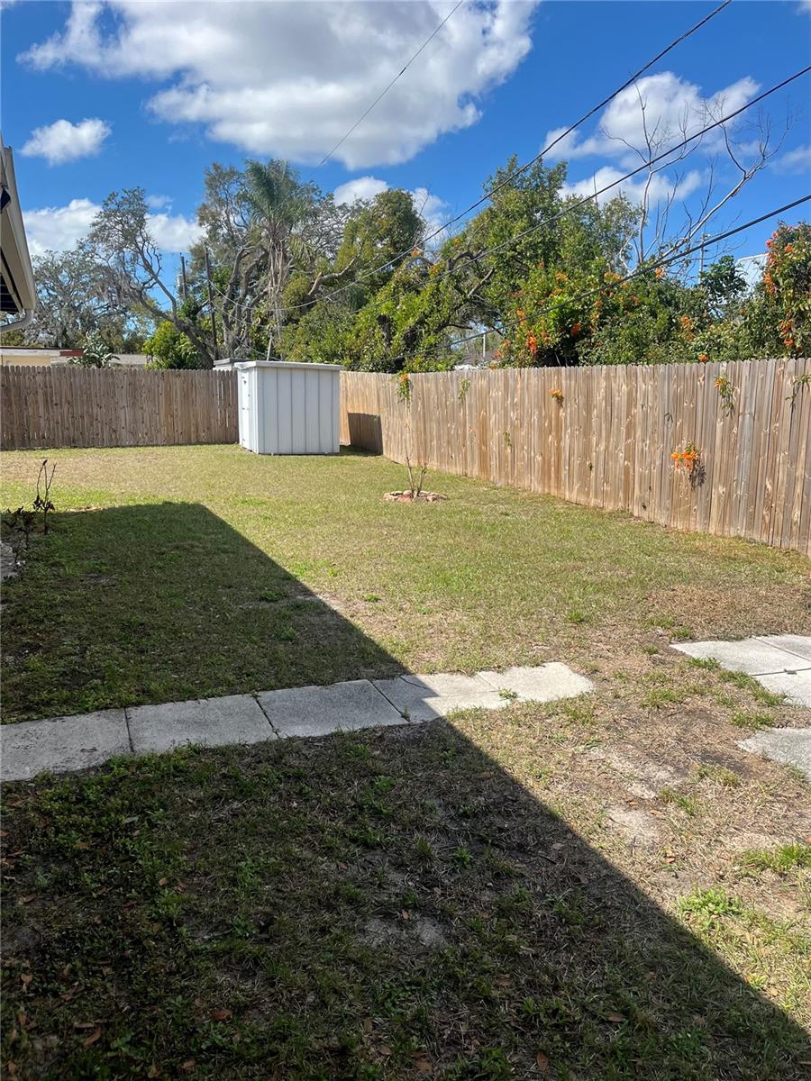Privacy Fenced backyard with storage shed