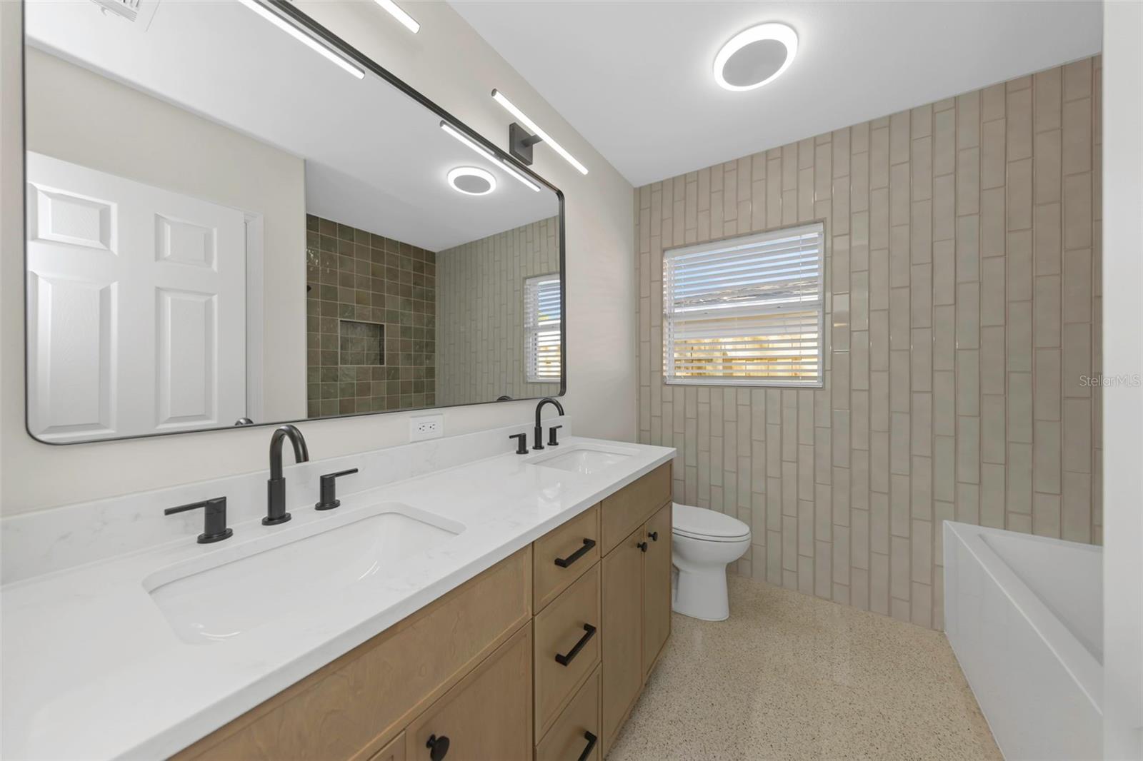 3rd full bathroom with double sinks and shower / tub combination.