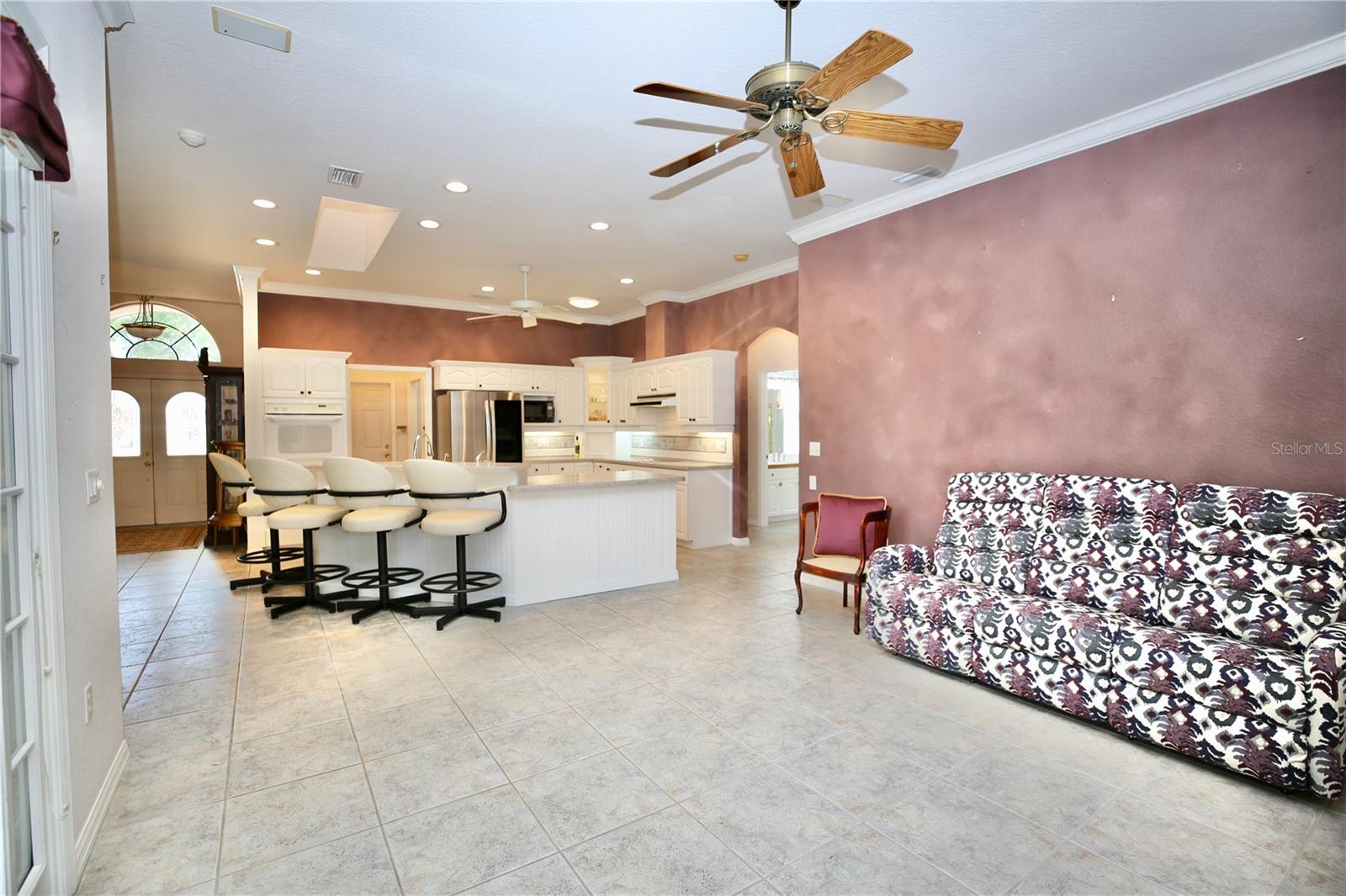 Open family room with high ceilings and kitchen with recessed lights