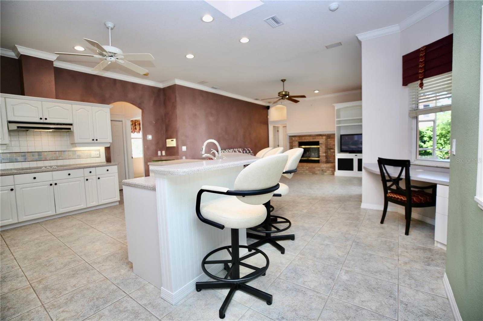 Kitchen with large island, bar area for seating, desk and open to family room