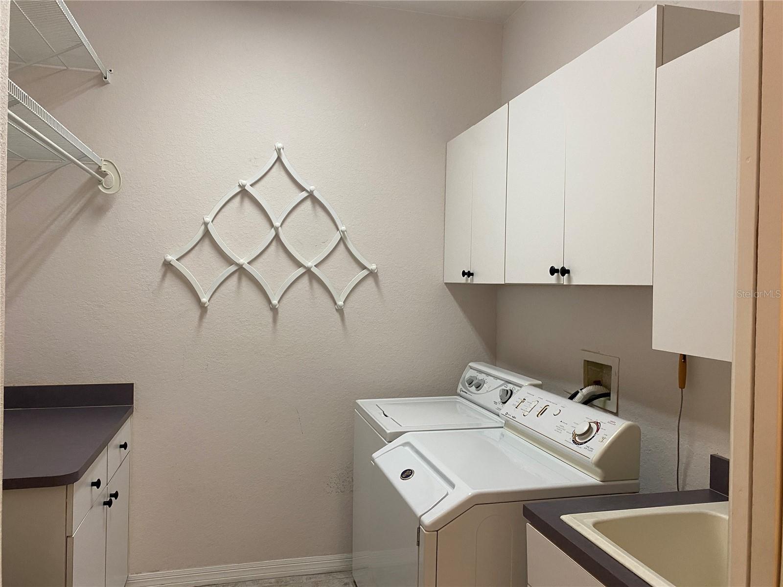 Largo laundry room with washer and dryer and laundry sink