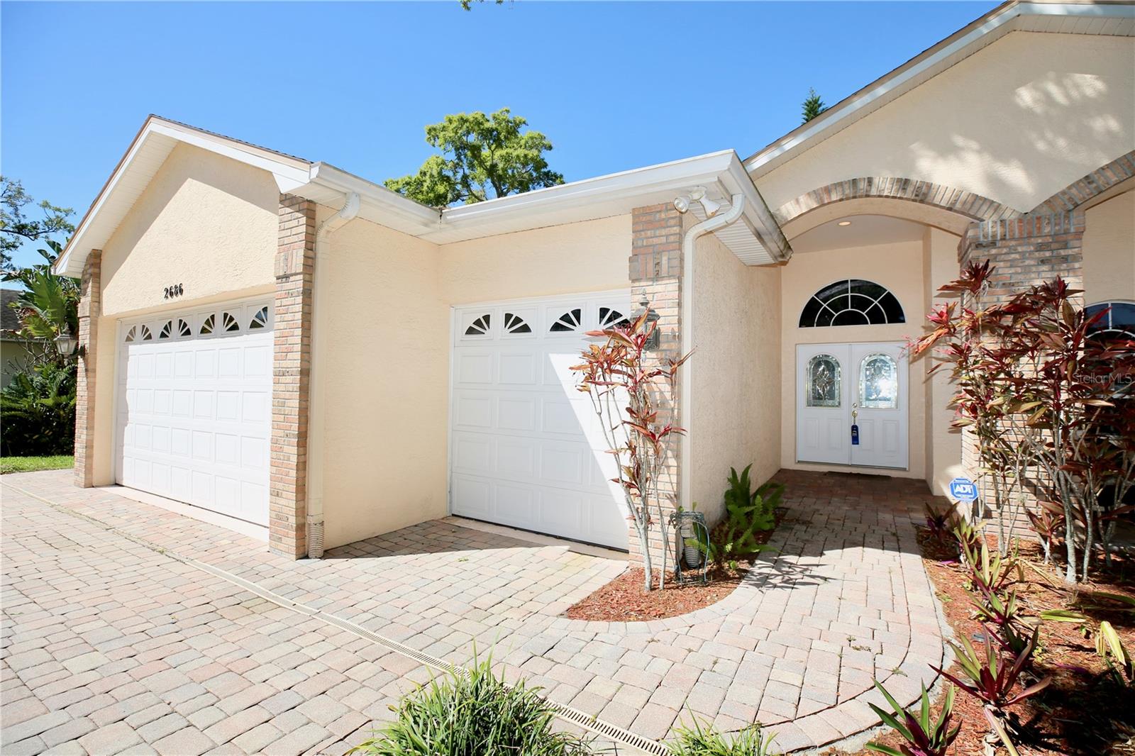 3 car garage and ample parking with paver driveway and walkway