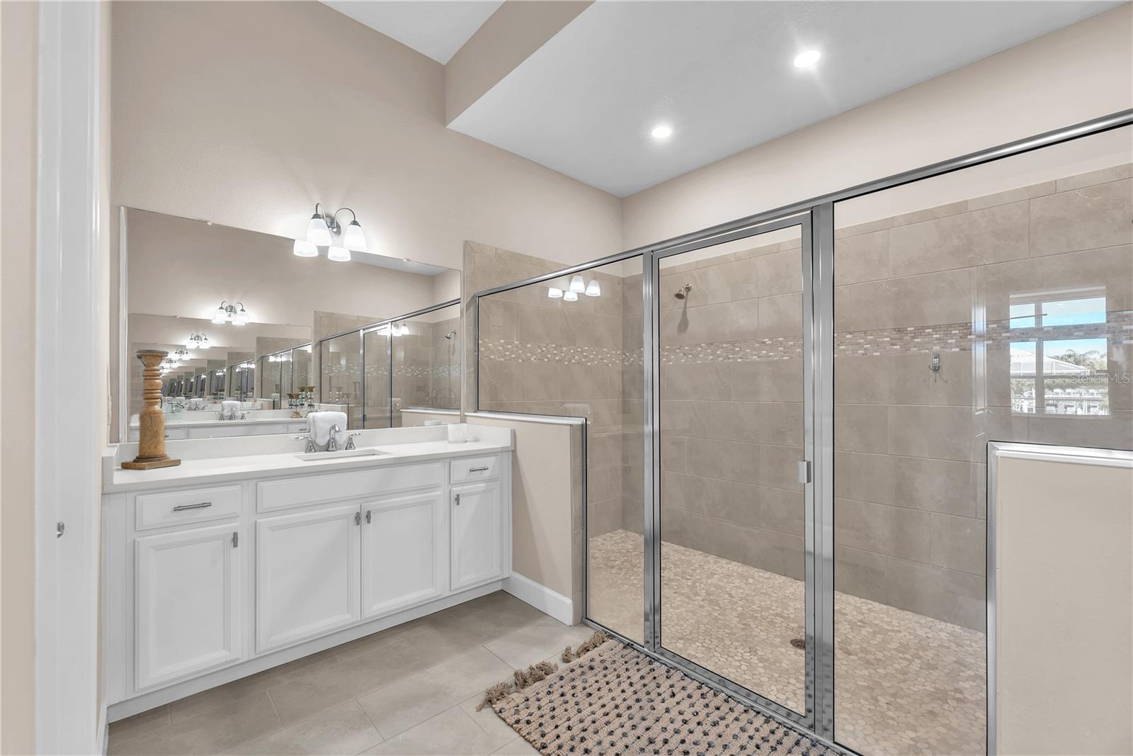 The owner’s bathroom features dual quartz vanities and an oversized two-person shower.