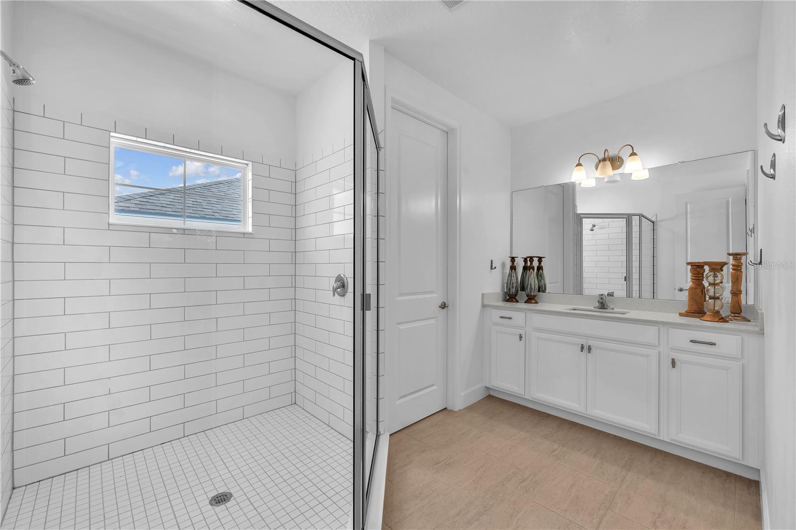 Secondary ensuite with large shower, water closet and vanity with single sink.